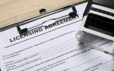 Licensing agreement document and stamp on wooden table, above view