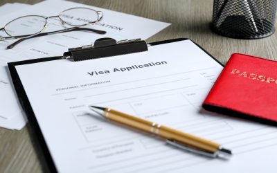 Visa application form for immigration, passport and pen on table, closeup